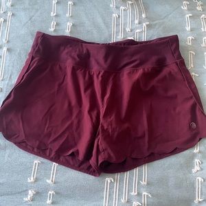 Maroon athletic shorts with scalloped detail. Size L.